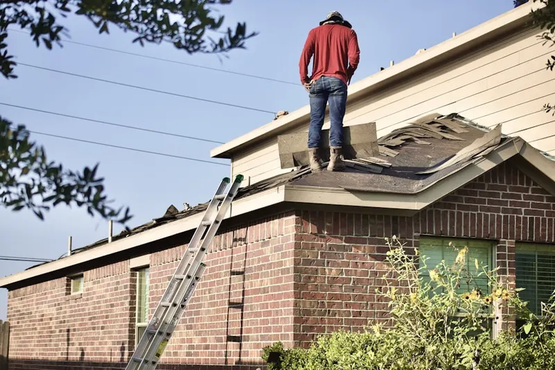 Professional roofer working on a residential roof in Fitch